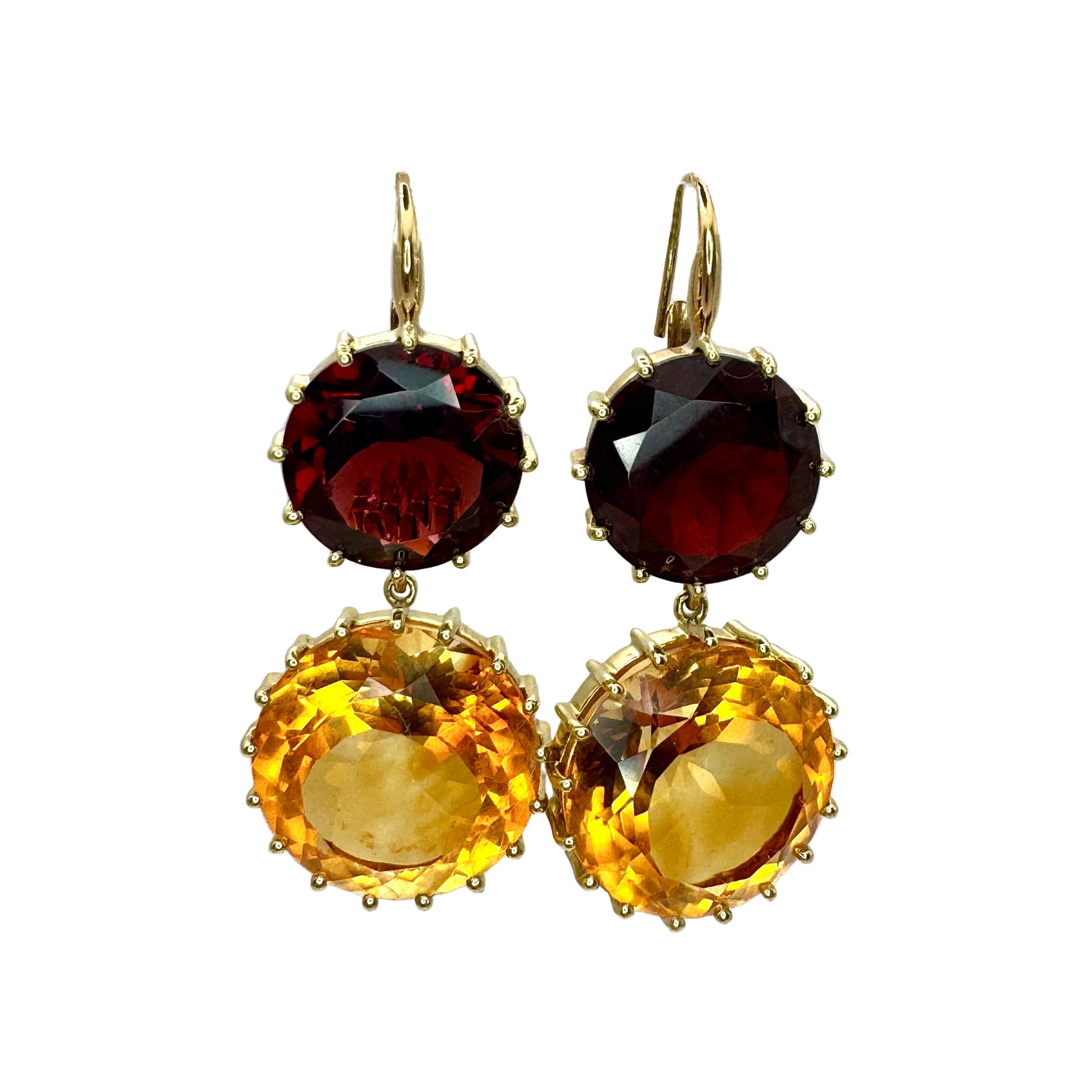 Pair of earrings with red and yellow gemstones on a white background.