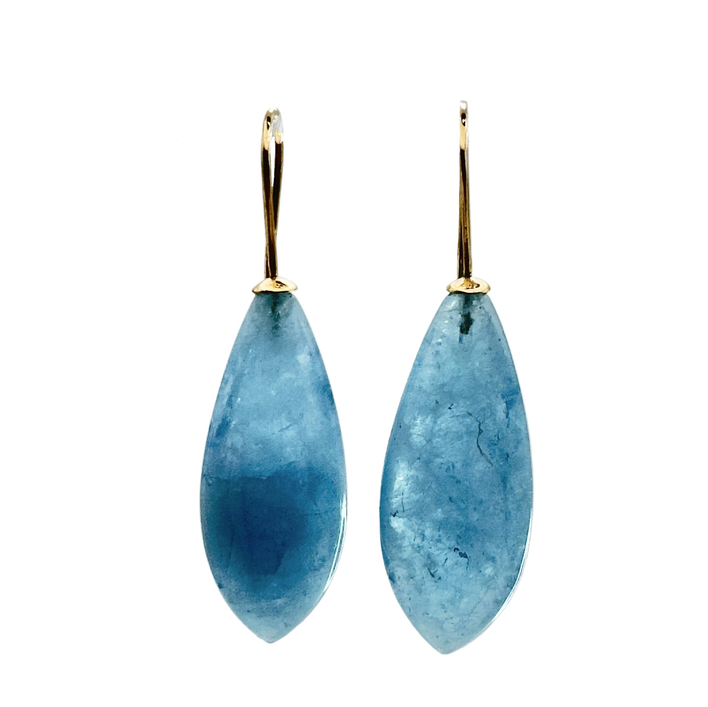 Teardrop-shaped blue earrings on a clear stand against a gray background