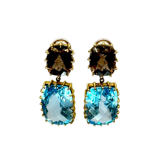 Pair of earrings with smoky topaz and blue topaz stones on a white background.