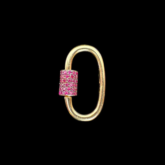 Gold loop clip with a pink gemstone on a black background