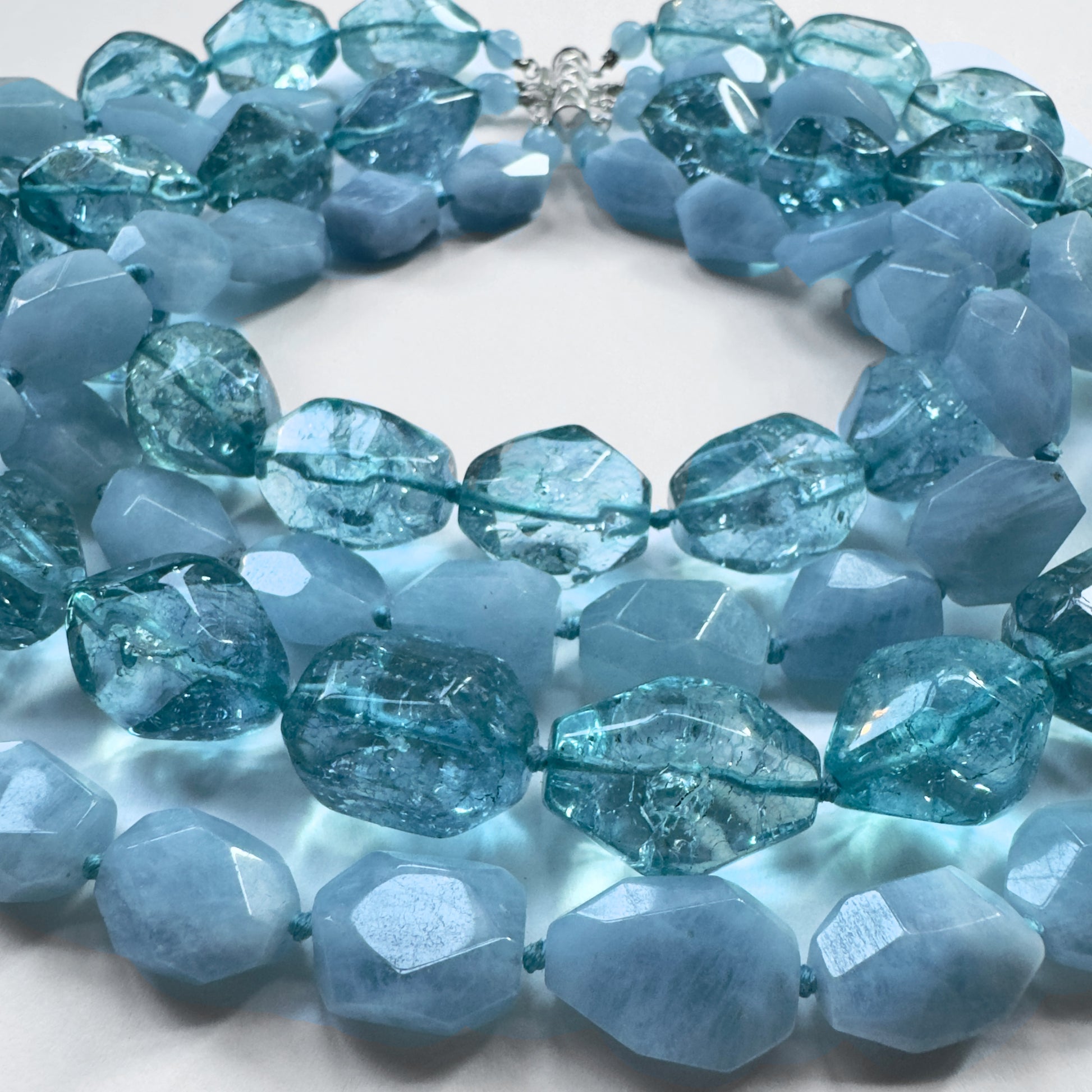 Necklace with blue faceted beads on a white background