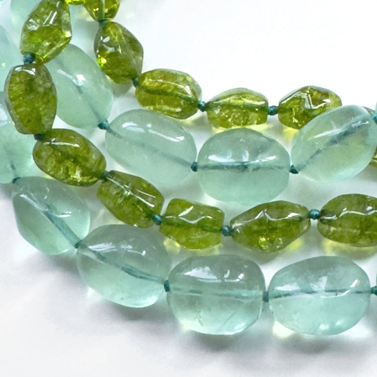 Necklace with green and clear beads on a white background