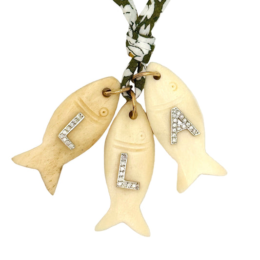 Necklace with fish-shaped pendants and diamond letters on a white background
