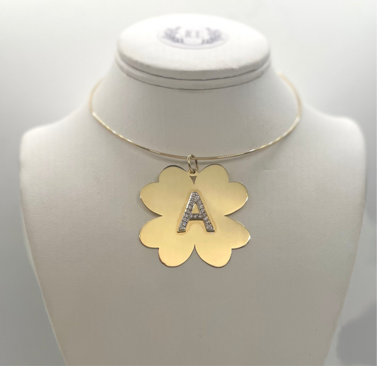 Gold necklace with a clover shaped pendant and letter 'A' on a mannequin bust.