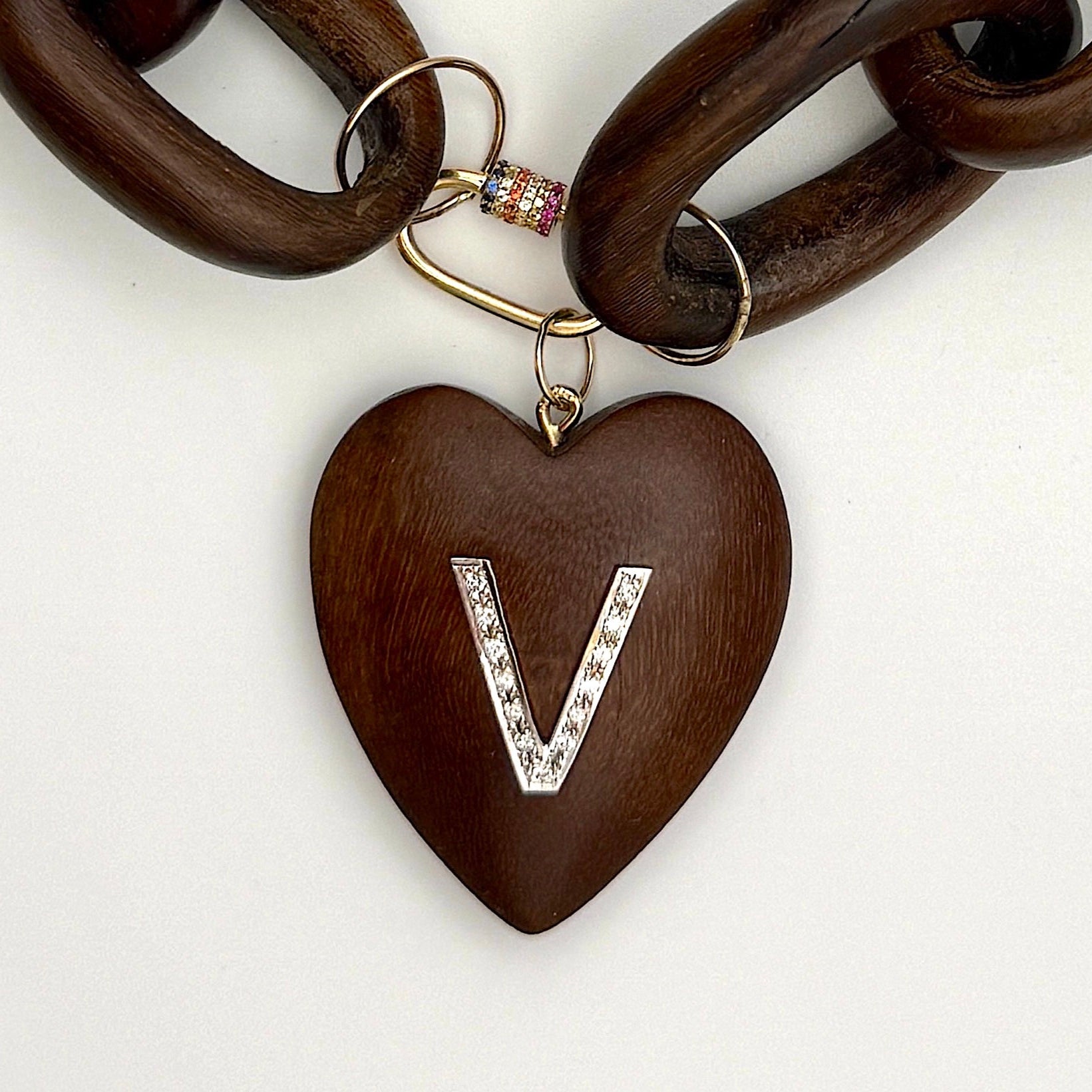 Wooden heart-shaped keychain with letter 'V' charm on a white background