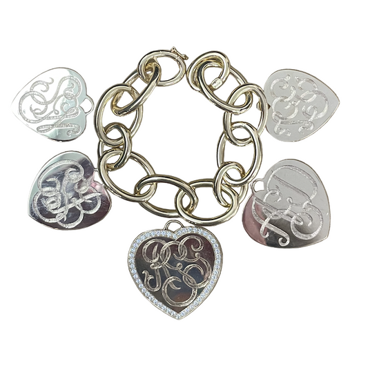 A gold oval link bracelet with five heart-shaped pendants, some with intricate details and pave diamonds.