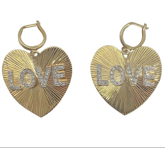 A pair of gold heart-shaped earrings with the word 'love' written in sparkling diamonds.
