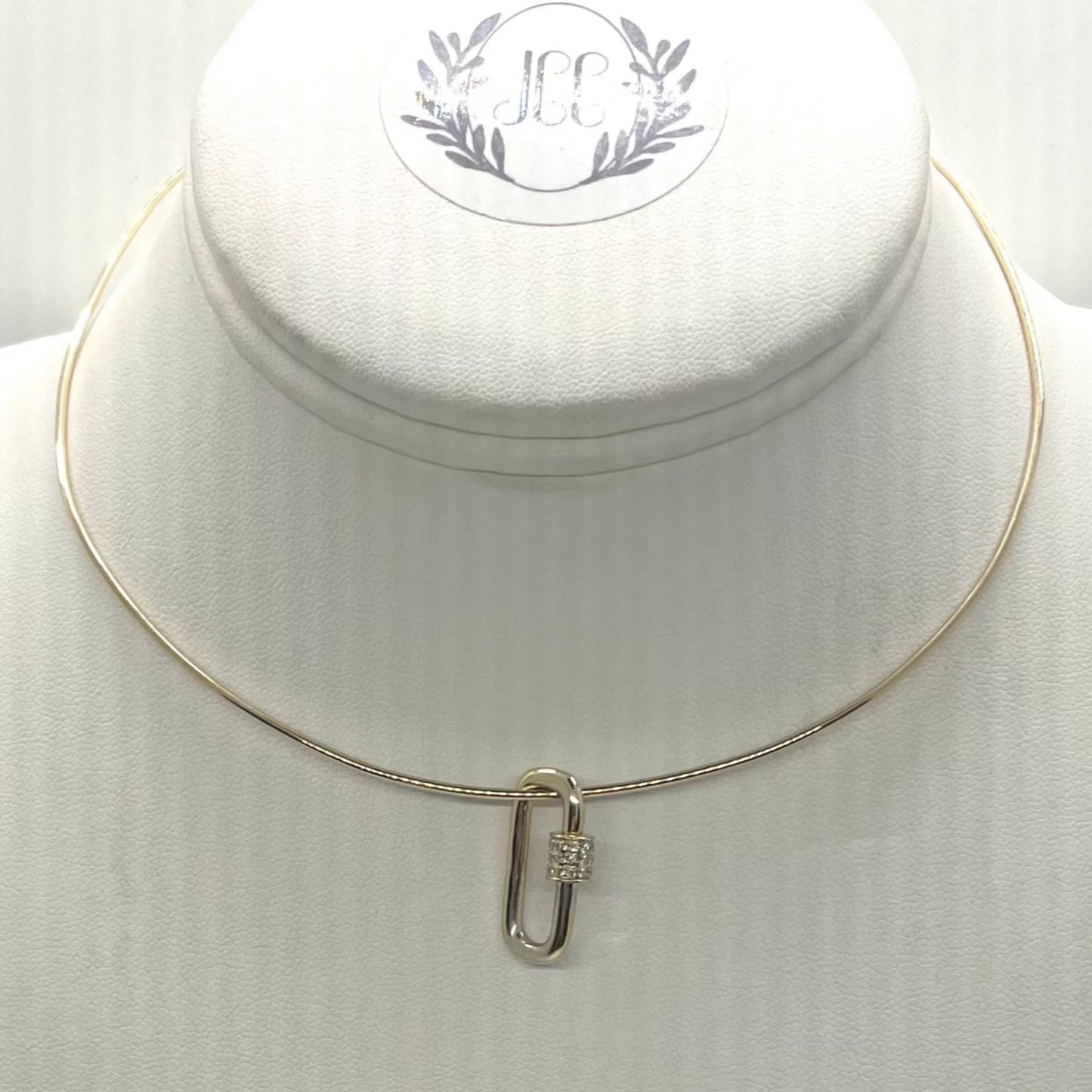 A yellow gold clip with a pave diamond closure displayed on a white mannequin necklace.