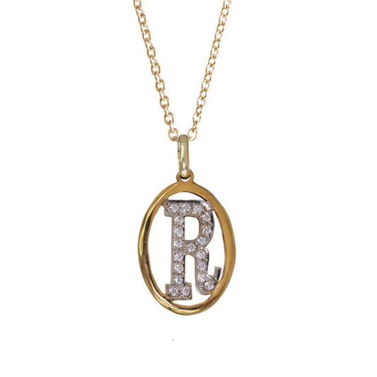 A 14k yellow gold framed letter charm with pave diamonds, displayed on a linen ribbon.