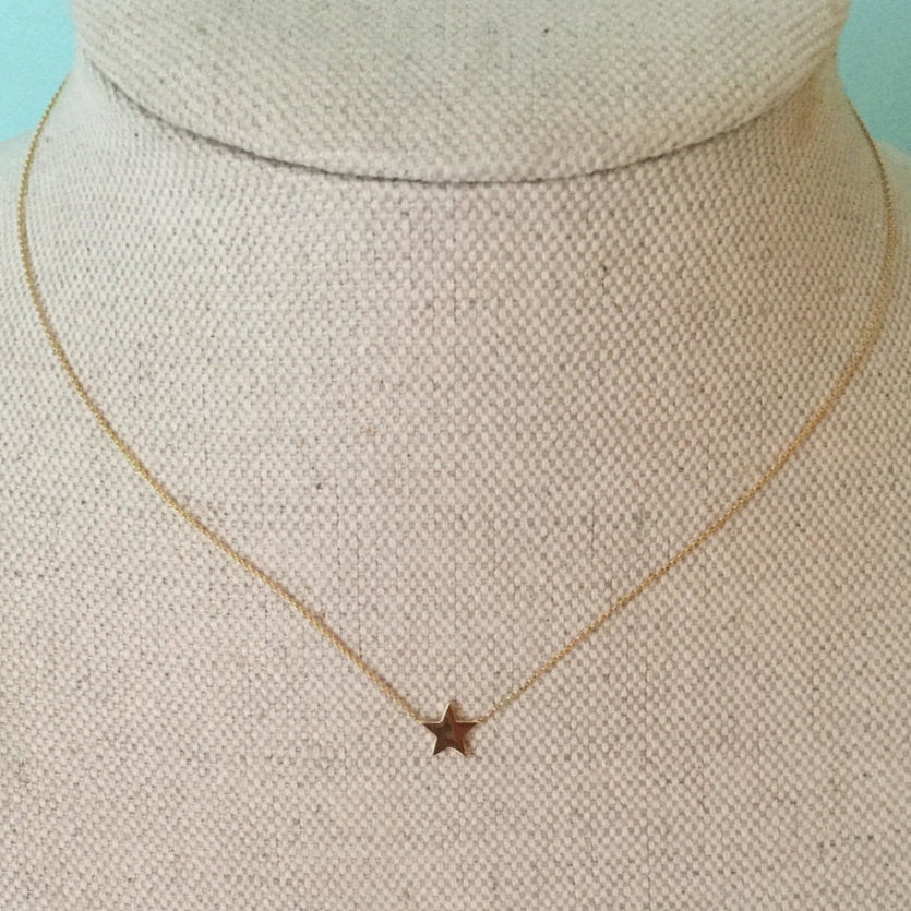 A 16 inch gold chain necklace with a 1/4 star-shaped pendant on a mannequin bust.