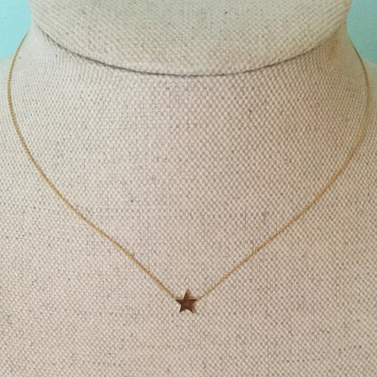 A 16 inch gold chain necklace with a 1/4 star-shaped pendant on a mannequin bust.