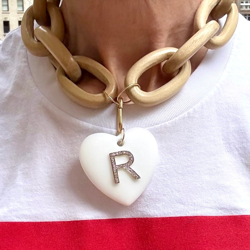Wooden chain necklace with a heart-shaped pendant featuring the letter 'R' on a white background.