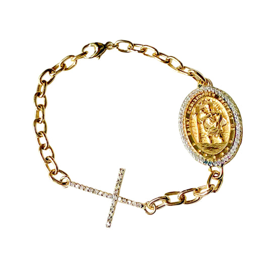 Gold bracelet with a central medallion and a cross on a light background