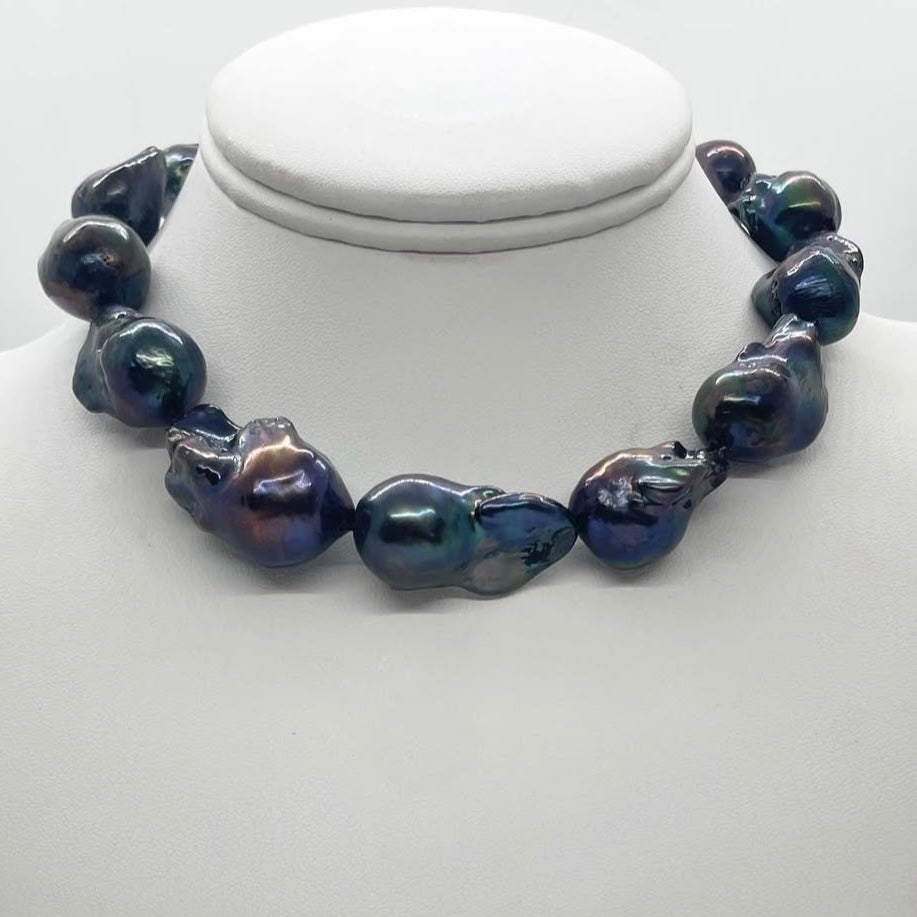 Necklace with dark blue pearls on a white mannequin bust