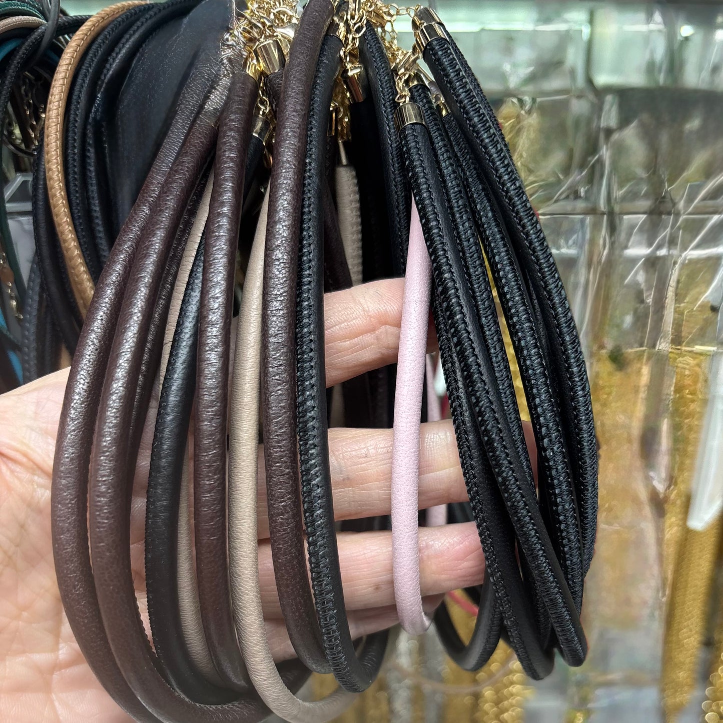 Collection of leather necklaces in various colors on a hand