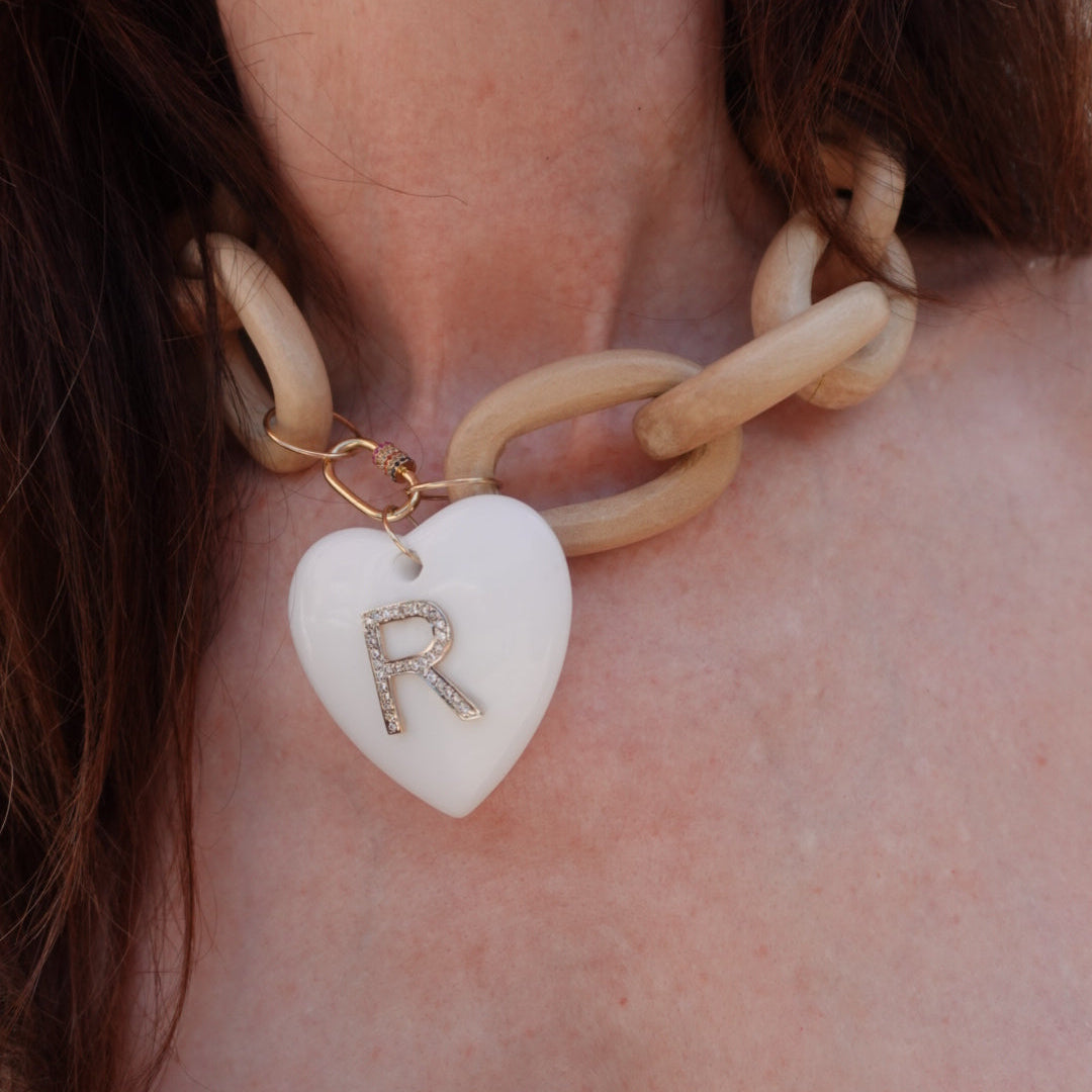Close-up of a necklace with a heart-shaped pendant and gold chain.