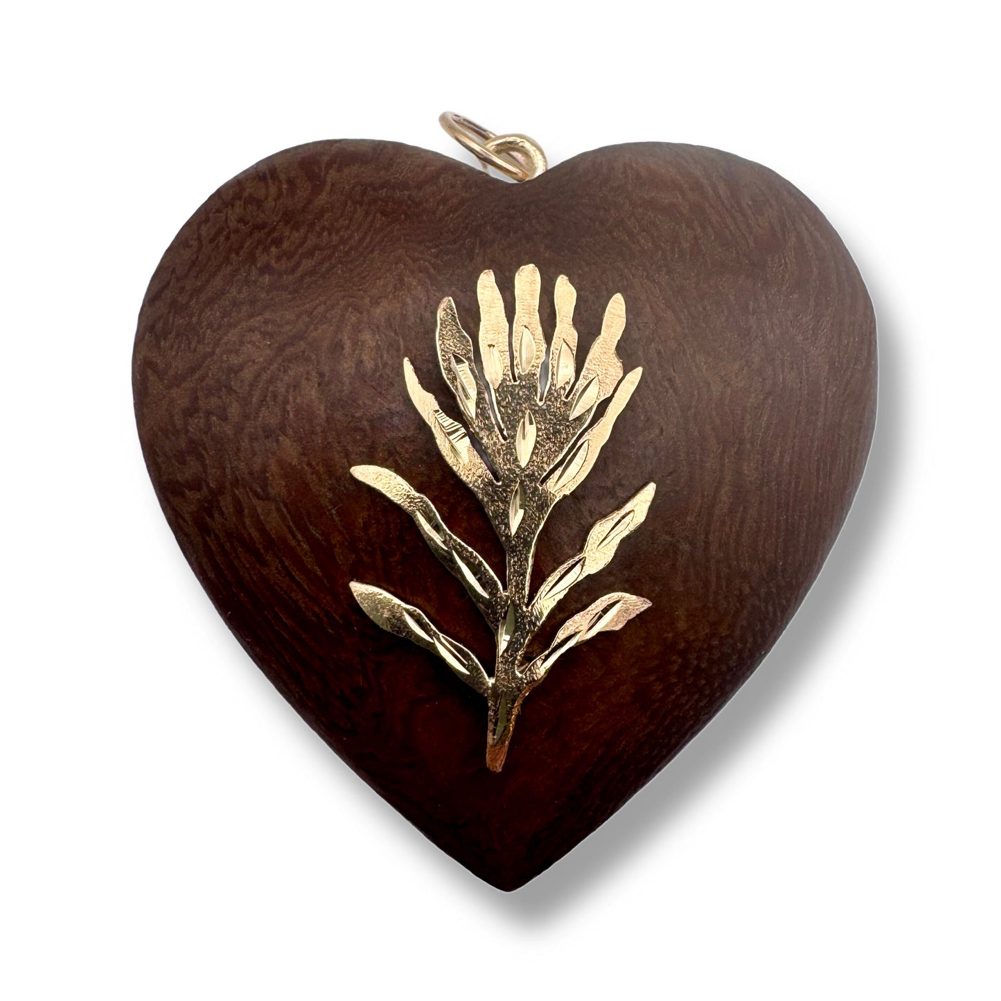 A heart-shaped wooden pendant with a dark brown wood grain finish and a textured gold metal floral inlay in the center, shown on a white background.