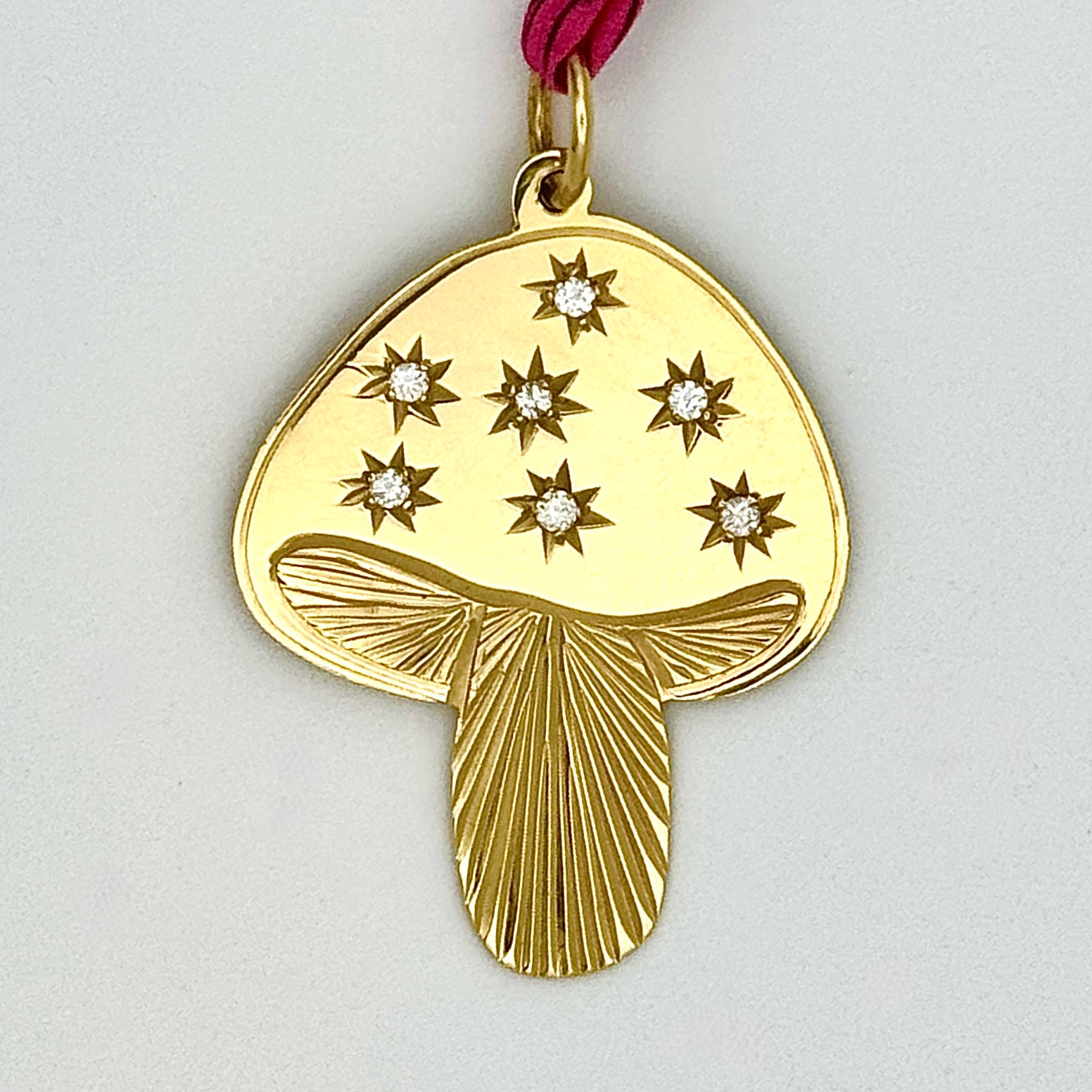 Mushroom shaped gold pendant with diamonds.