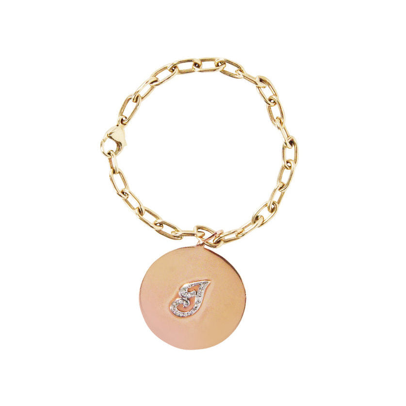 A 14K Yellow Gold charm bracelet with a 1 1/4” disk charm on a 14kt gold link 7” chain, featuring a pave diamond initial.
