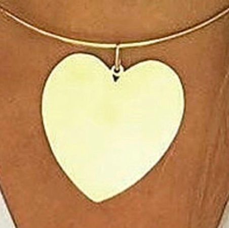 Heart shaped pendant necklace on a person wearing a white shirt. 