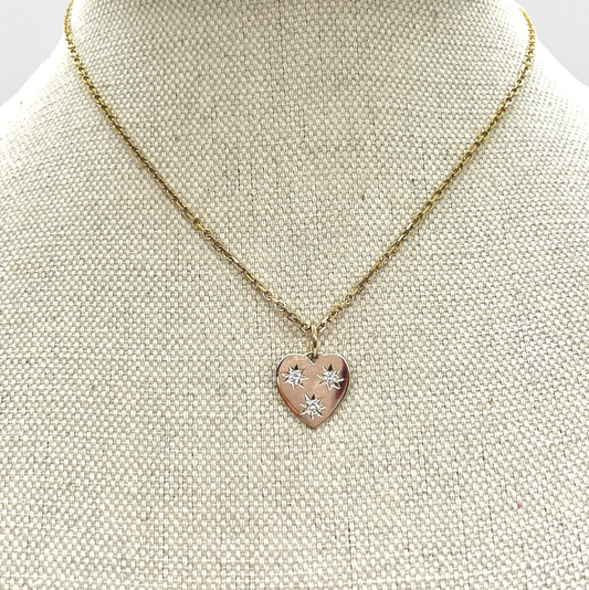 Small heart shaped pendant necklace with diamonds on bust. 