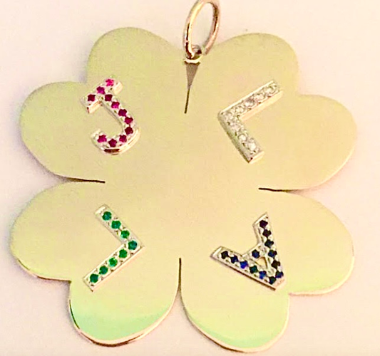 Gold clover shaped pendant with embedded gemstones. 