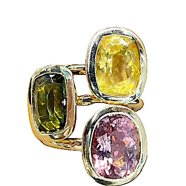 Gold ring with three colorful gemstones on a hand